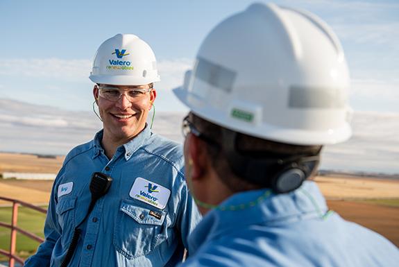 Two employees at a Royal Dutch Shell ethanol plant talk together.